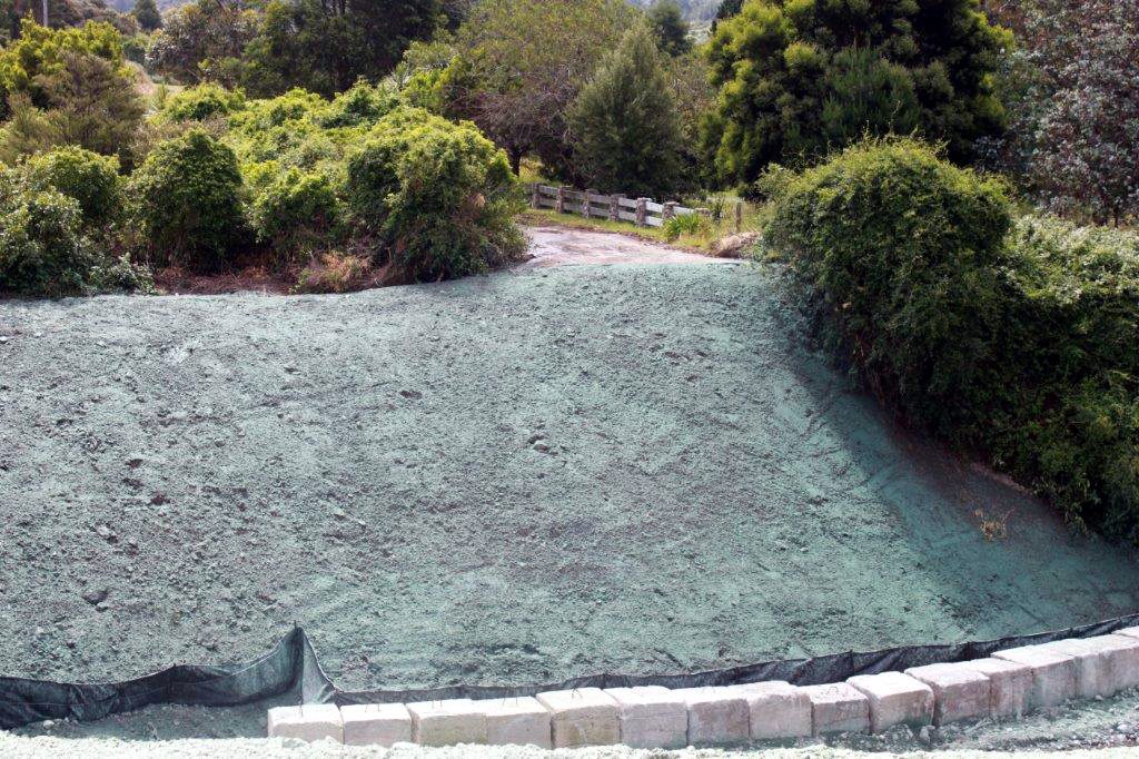 Hydromulch applied to a bank beside native bush