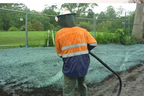 Operator applying hydroseed slurry by hose to a prepared area