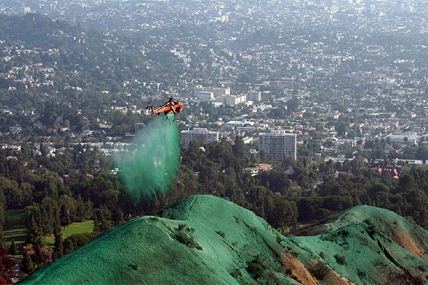 Hydroseeding a steep slope high above Wellington city